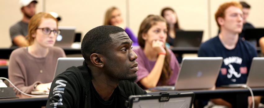 Students sitting in classroom listening to lecture.